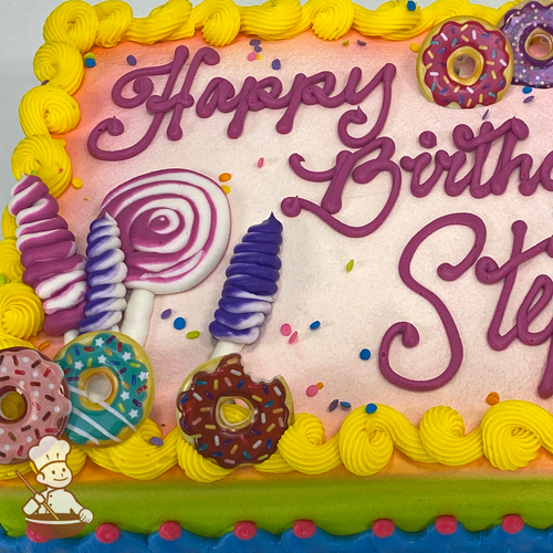 Birthday sheet cake with buttercream candy lollipops and donut toy rings and spinkles.