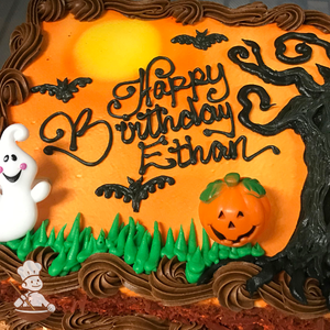 Sheet cake with buttercream haunted tree and bats with pumpkin and ghost toy decorations and full moon.
