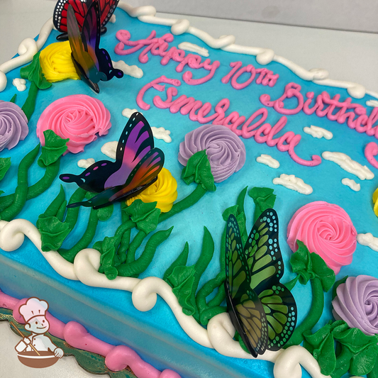 Birthday sheet cake with sky background and cute swirlette flowers on long stems with butterflies.