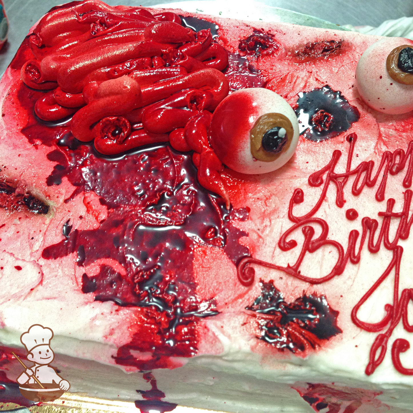 Birthday sheet cake with buttercream piped stomach and food coloring blood with eye balls.
