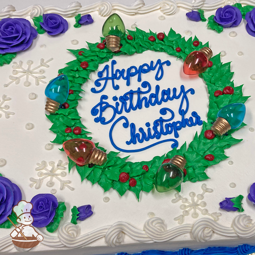 Christmas sheet cake with roses, snowflakes and holiday wreath decorated with berries and holiday lights.