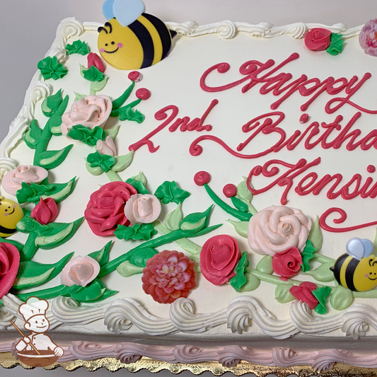 Birthday sheet cake with butterceram roses on long stems with toy bumble bee and flower rings.