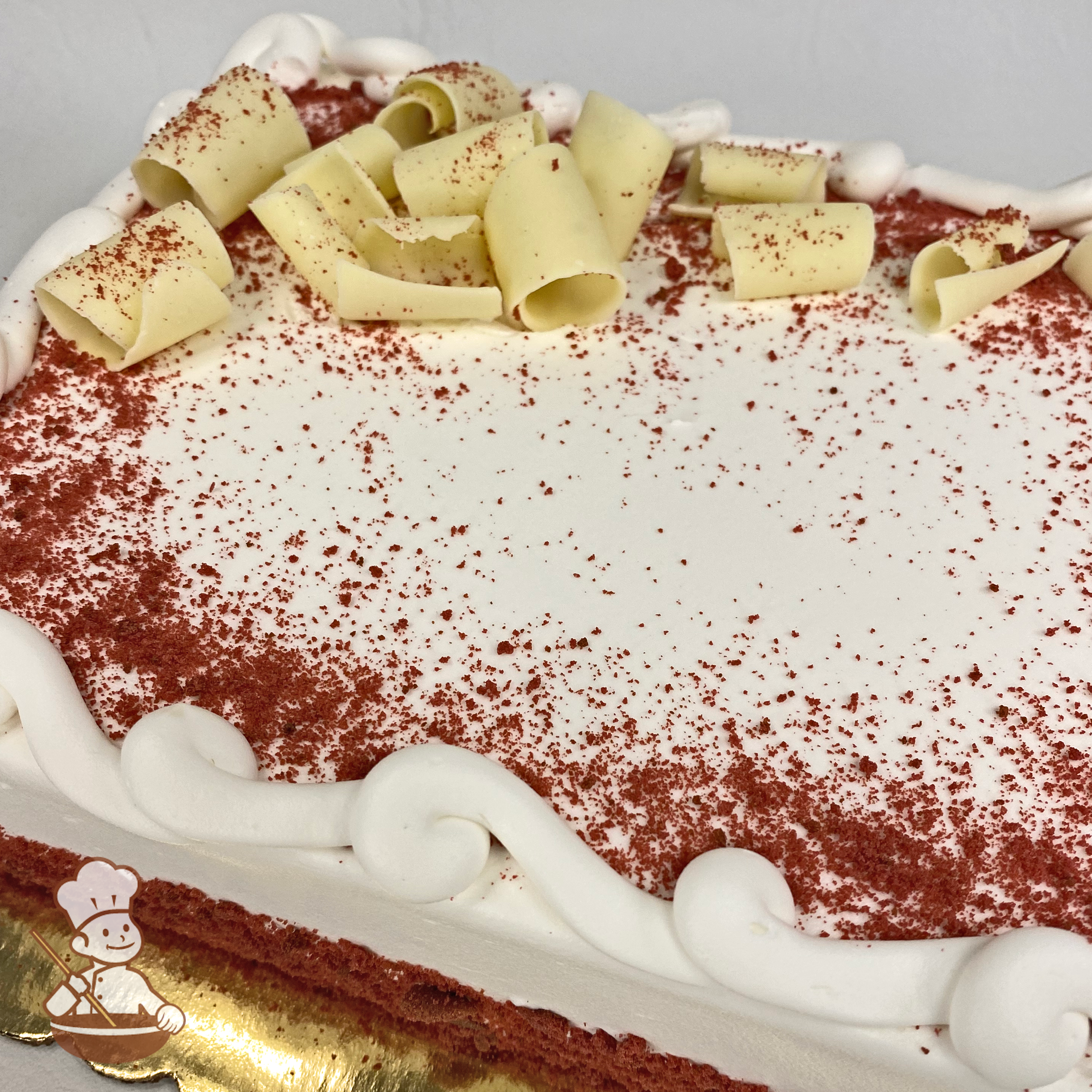 Sheet cake with red velvet cake crumbles and white chocolate curls.
