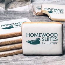 Load image into Gallery viewer, A stack of rectangle butter shortbread cookies with Homewood Suites by Hilton logo printed directly on a white, lemon sugar icing.