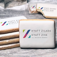 Load image into Gallery viewer, A stack of rectangle butter shortbread cookies with Hyatt Zilara logo printed directly on a white, lemon sugar icing.