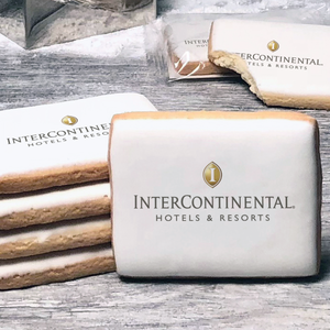 A stack of rectangle butter shortbread cookies with Intercontinental logo printed directly on a white, lemon sugar icing.