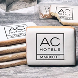 A stack of rectangle butter shortbread cookies with AC Hotels logo printed directly on a white, lemon sugar icing.