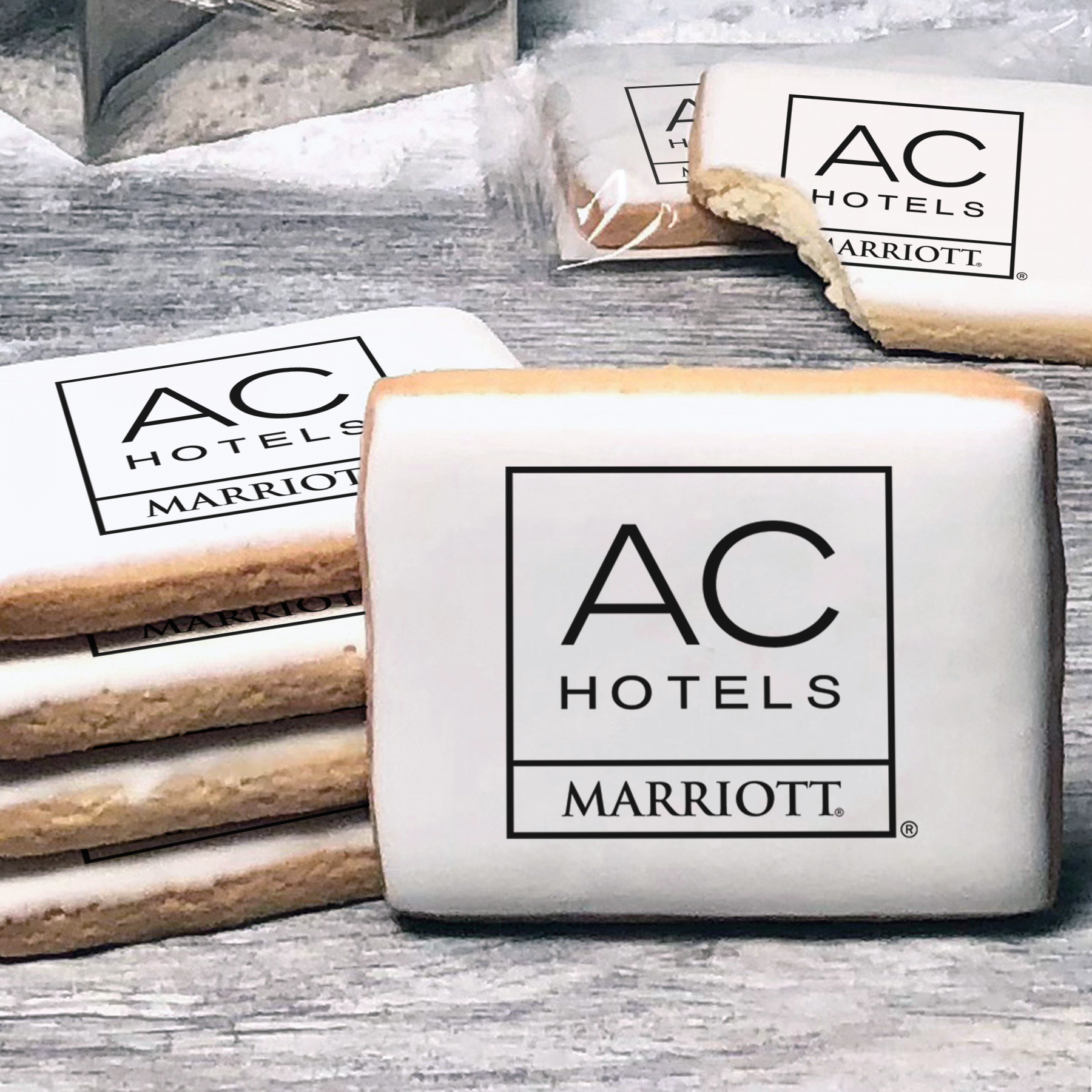 A stack of rectangle butter shortbread cookies with AC Hotels logo printed directly on a white, lemon sugar icing.