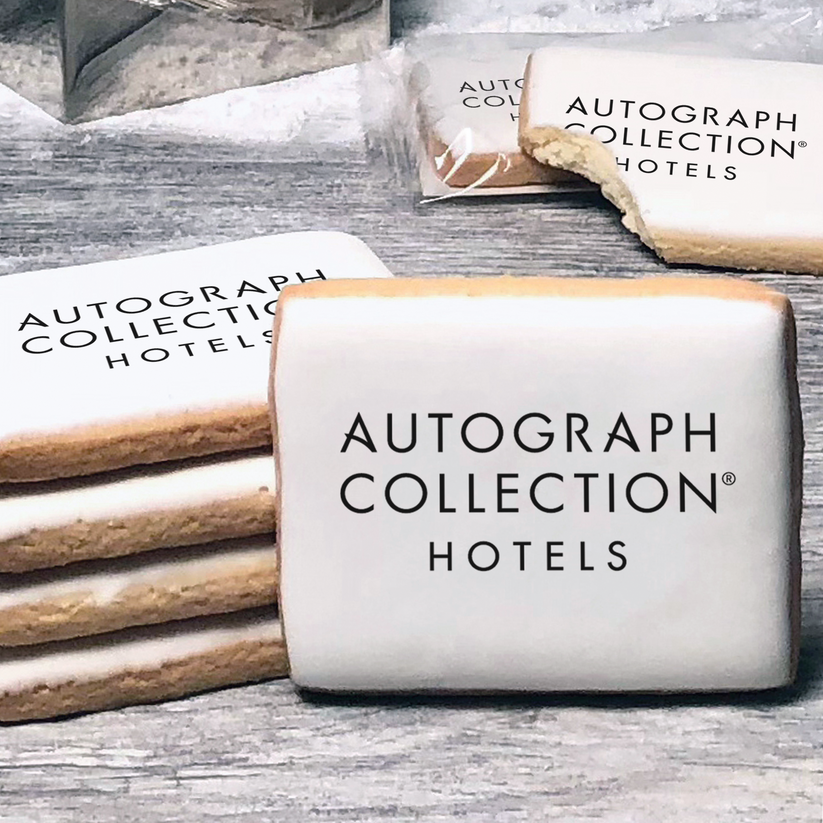 A stack of rectangle butter shortbread cookies with Autograph Collection logo printed directly on a white, lemon sugar icing.