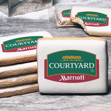 Load image into Gallery viewer, A stack of rectangle butter shortbread cookies with Courtyard logo printed directly on a white, lemon sugar icing.