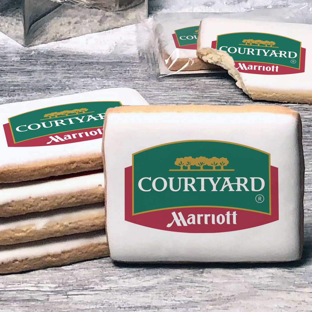 A stack of rectangle butter shortbread cookies with Courtyard logo printed directly on a white, lemon sugar icing.