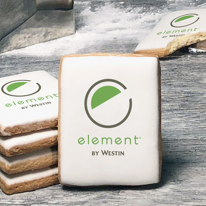 A stack of rectangle butter shortbread cookies with Element by Westin logo printed directly on a white, lemon sugar icing.