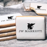 A stack of rectangle butter shortbread cookies with JW Marriott logo printed directly on a white, lemon sugar icing.