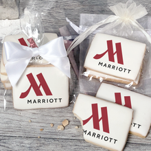 Load image into Gallery viewer, A stack of rectangular butter shortbread cookies with Marriott logo printed directly on a white, light sugar icing. Some cookies are shown in clear packaging with a twist-tie ribbon bow or inside an organza bag.