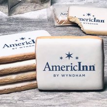 Load image into Gallery viewer, A stack of rectangle butter shortbread cookies with AmericInn logo printed directly on a white, lemon sugar icing.