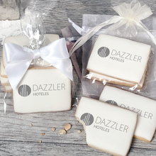 Load image into Gallery viewer, A stack of rectangular butter shortbread cookies with Dazzler logo printed directly on a white, light sugar icing. Some cookies are shown in clear packaging with a twist-tie ribbon bow or inside an organza bag.