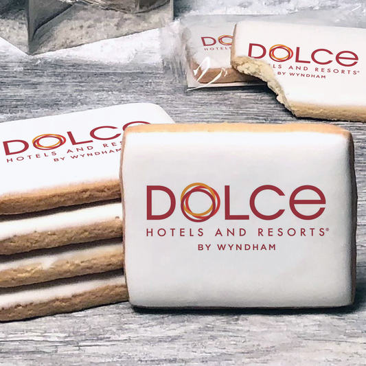 A stack of rectangle butter shortbread cookies with Dolce Hotels & Resorts logo printed directly on a white, lemon sugar icing.