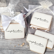 Load image into Gallery viewer, A stack of rectangular butter shortbread cookies with Esplendor logo printed directly on a white, light sugar icing. Some cookies are shown in clear packaging with a twist-tie ribbon bow or inside an organza bag.