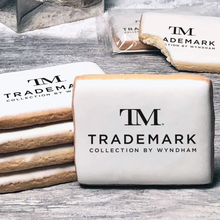 Load image into Gallery viewer, A stack of rectangle butter shortbread cookies with TM Trademark Collection by Wyndham logo printed directly on a white, lemon sugar icing.