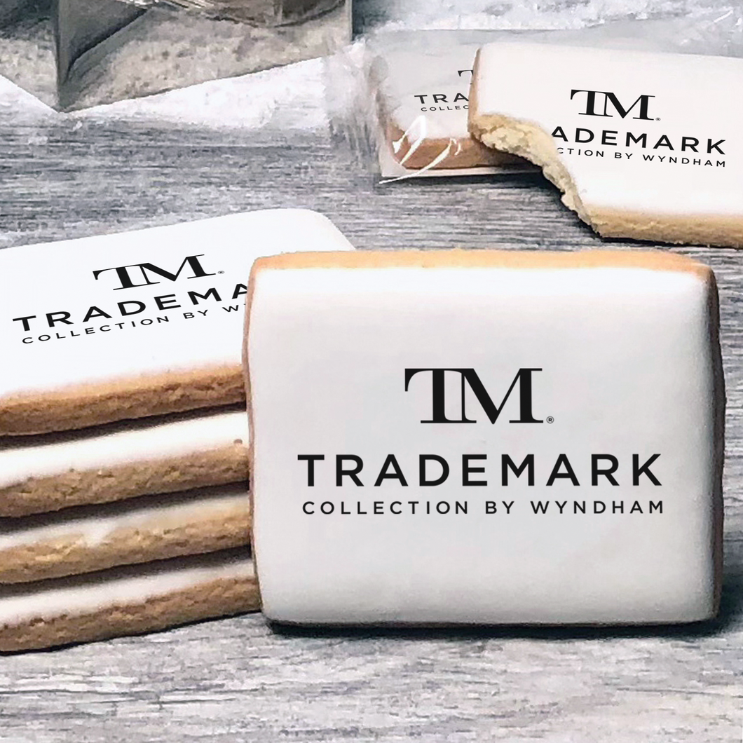 A stack of rectangle butter shortbread cookies with TM Trademark Collection by Wyndham logo printed directly on a white, lemon sugar icing.