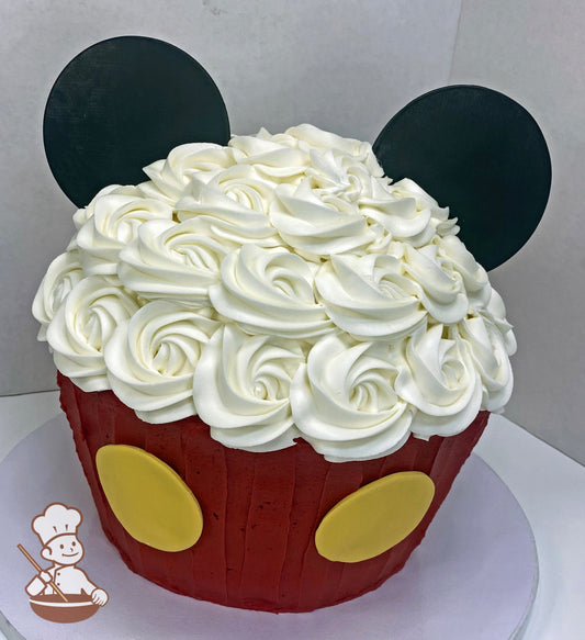 Cake decorated to look like a big cupcake with Mickey Mouse colors and black fondant Mickey Mouse ears.