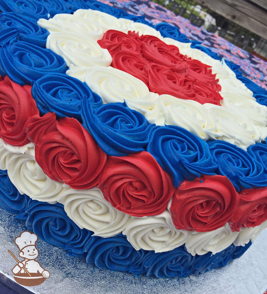 Single tier cake decorated with red, blue and white buttercream rosette swirls.