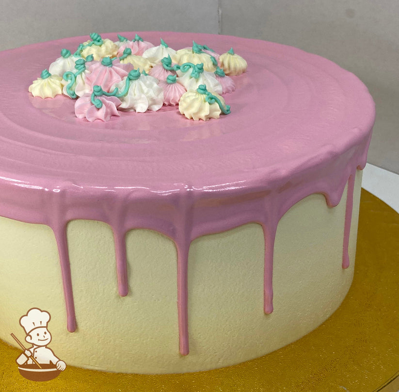 Single tier cake with an off-white icing, and decorated with a pink drip and small buttercream pumpkins in white, pink and cream colors.