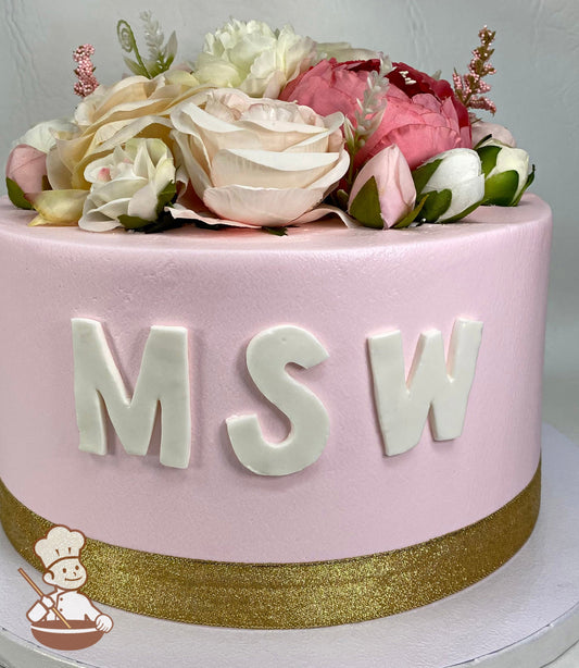 Single tier cake with smooth pink icing and decorated with a fondant MSW message on the front of the cake and an assortment of silk florals.