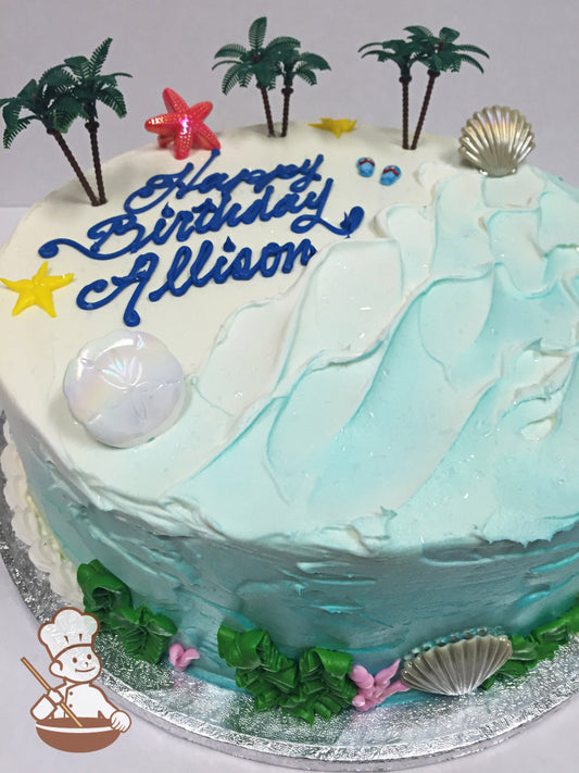Cake decorated with textured icing to look like a beach with piped buttercream seaweed, coral, starfish and plastic palm trees and seashells.
