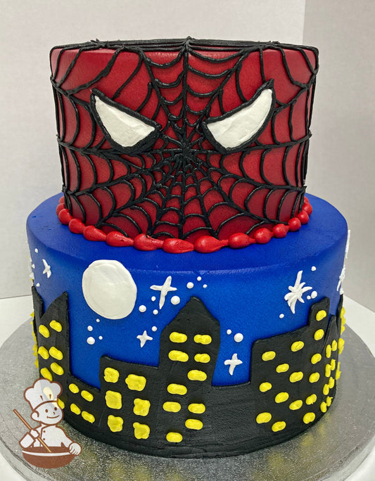 Cake decorated with blue icing and a black buttercream skyline on the bottom tier and red icing and a hand-piped Spider-Man face on the top tier.
