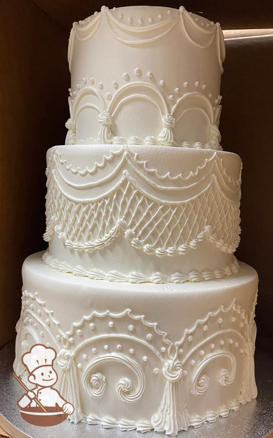 3-tier cake with smooth white icing, decorated with intricate and detailed buttercream piping's.