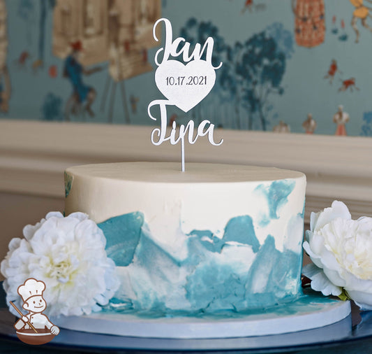Single tier round cake with white icing and added dusty blue textured icing streaks on the cake wall.