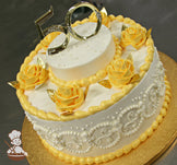 Single tier round cake with white icing and white scrolls on cake wall. The cake also yellow-gold buttercream roses with metallic gold leaves.
