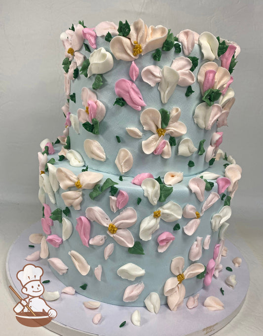 2-tier round cake with smooth light blue icing and buttercream flowers in light pink, peach and white colors.