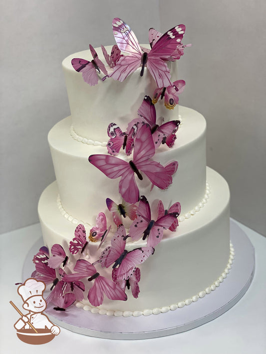 3-tier round cake decorated with smooth white icing and fake pink butterflies.