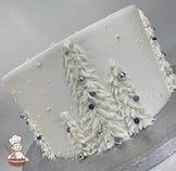 Single tier cake with smooth white icing and buttercream white trees with silver, white, gray and blue sugar pearls.