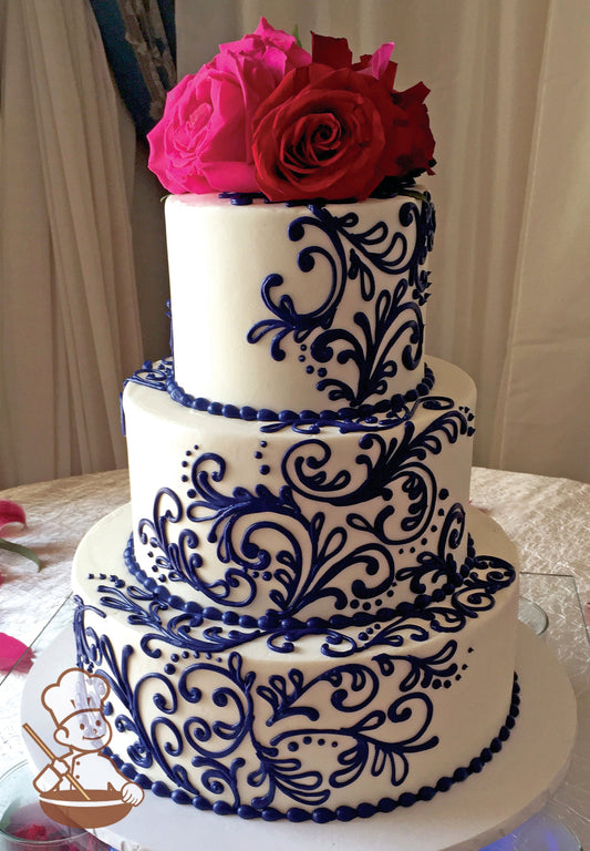 3-tier cake with smooth white icing and decorated with navy-blue buttercream scrolls and navy-blue beaded trims with hot-pink roses on top.