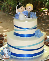 2-tier cake with smooth white icing and blue and light-blue ribbon placed criss-cross all over the cake.