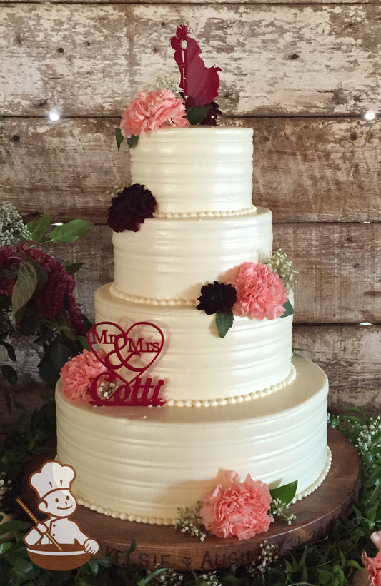 4 tier round wedding cake with smooth round buttercream patterns and finished with fresh flowers and cake topper.