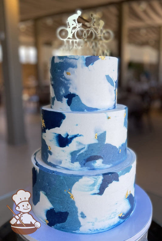 3 tier wedding cake with blue tones marble buttercream pattern and touches of gold leaf added.