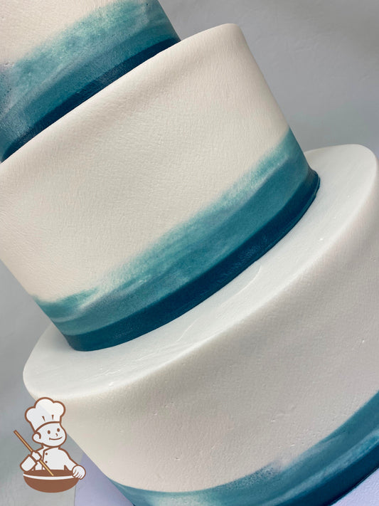 3 Tier Wedding Cake with Dusty Blue buttercream water color tones pattern on base of each tier with navy blue fondant band wrap.