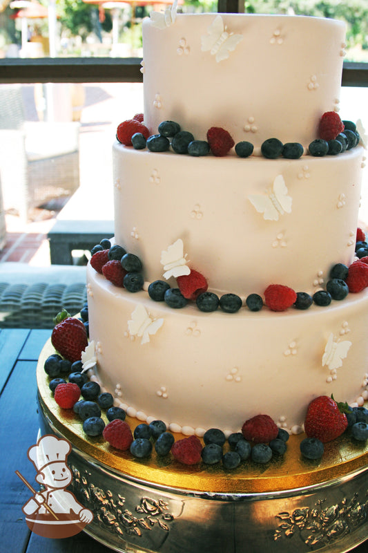 3 Tier Wedding cake with tri dot piping design and decorated with sugar butterflies and fresh berry fruits.