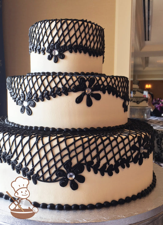 3 tier buttercream wedding cake with black lace and heart shaped vintage piping.  Florals with rhinestone centers for the added design.