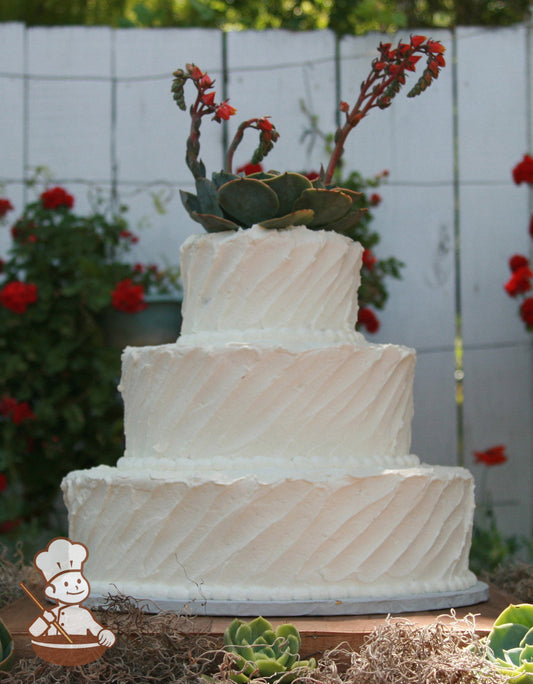 3-tier cake with white icing with a rustic diagonal texture and white beaded trims.