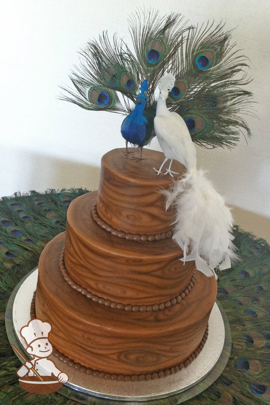3-tier cake with white icing that has been airbrushed with brown colors to look like wood and brown buttercream beaded trims.