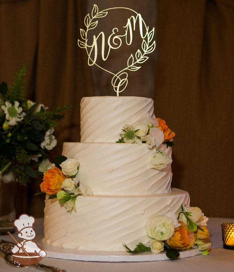 3-tier cake with white icing and decorated with a diagonal angle texture and white and orange fresh flowers.