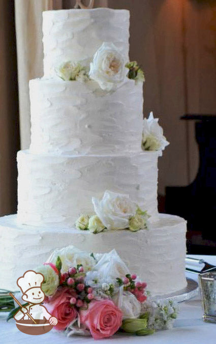 4-tier cake with white icing and decorated with an all over texture and fresh flowers in white and cream colors.
