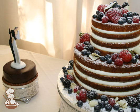 2-tier cake with no icing, showing the inside of the cake and filling and decorated with fresh strawberries, blueberries and raspberries.