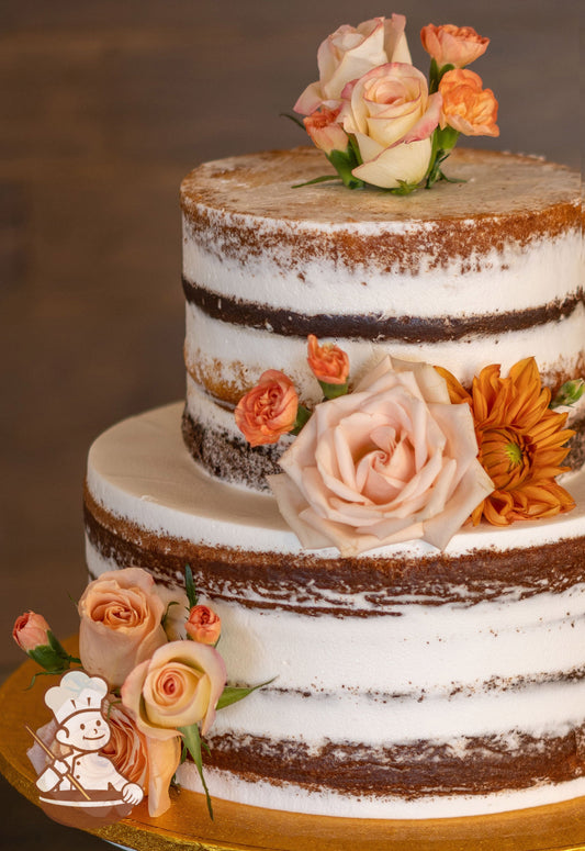 2-tier cake with white icing decorated with a scraped texture to show a lot of the cake and fresh flowers.