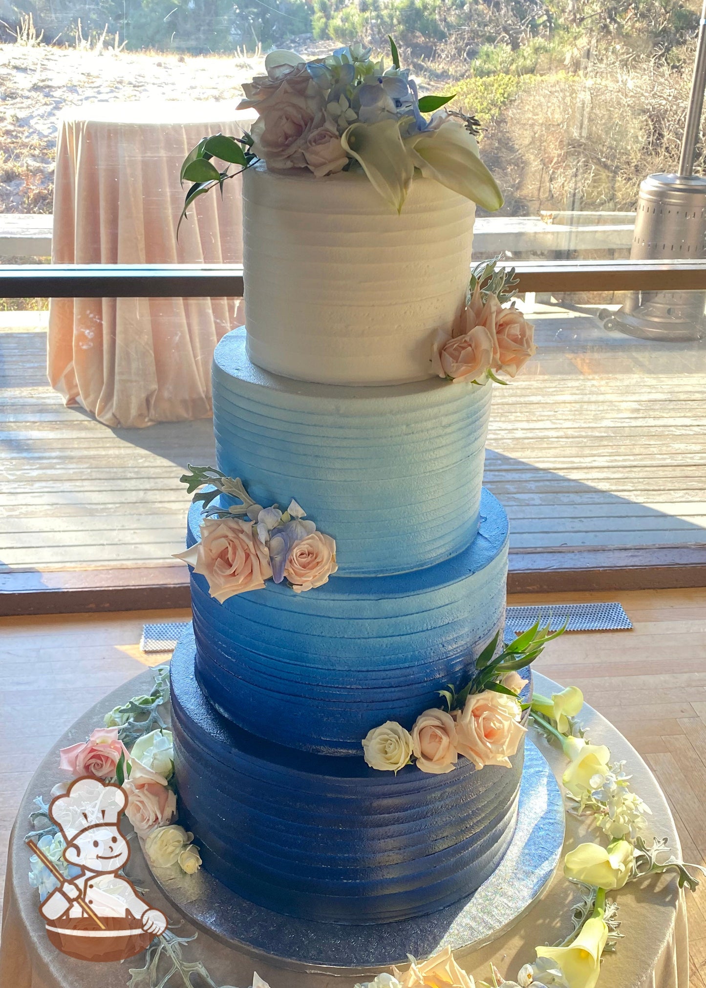 Cake with white icing decorated with a light horizontal texture and an airbrushed ombre coloring starting with dark-blue at bottom to white.